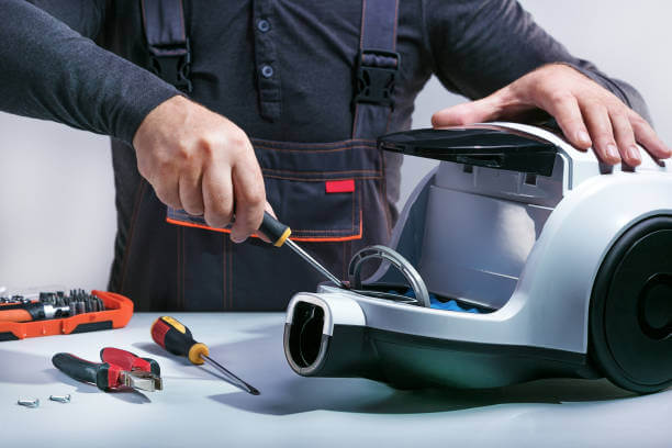 Repairman repairing of vacuum cleaner. Small business.